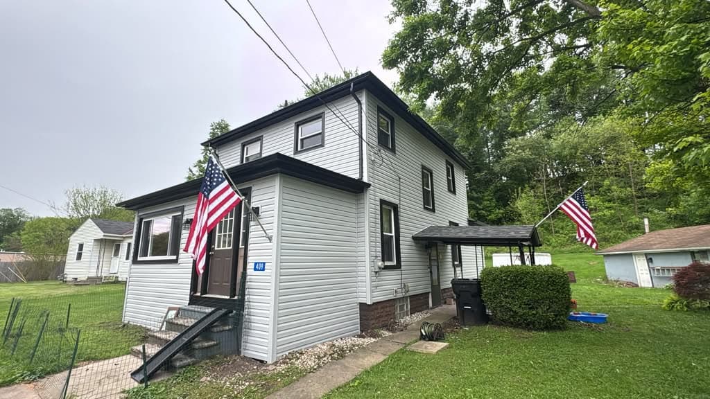 White vinyl siding with black trim, front of a Pittsburgh home